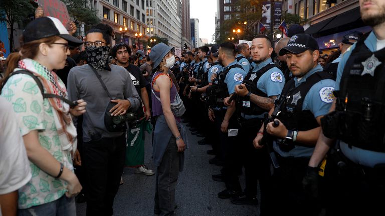 Polis memurları, insanlar Chicago'daki federal göç taramalarına karşı protesto gösterdikçe nöbet tutuyorlar.  Pic: Reuters