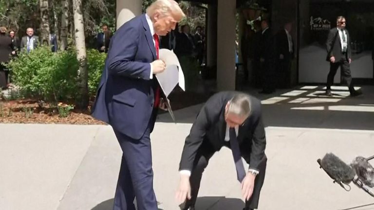 Trade deal papers fall on the floor as Donald Trump holds them up for cameras - and Sir Keir Starmer picks them up