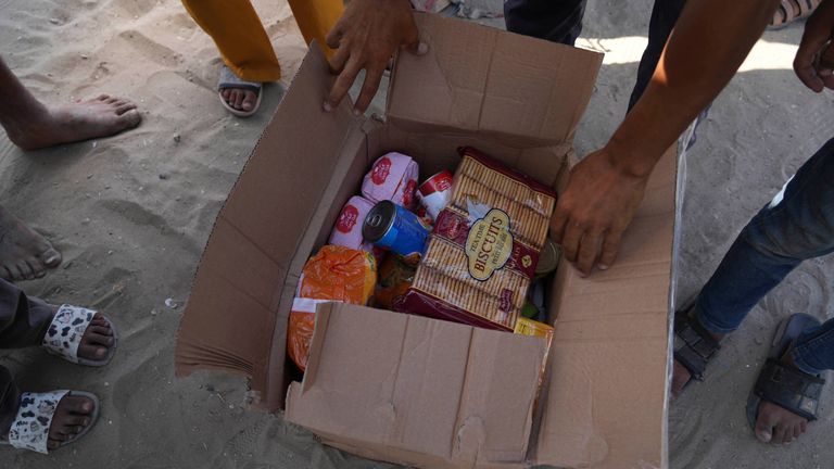 Palestinians open a box containing food and humanitarian aid packages delivered by the Gaza Humanitarian Foundation, a U.S.-backed organization approved by Israel, in Rafah, southern Gaza Strip, on Tuesday, May 27, 2025. (AP Photo/Abdel Kareem Hana)