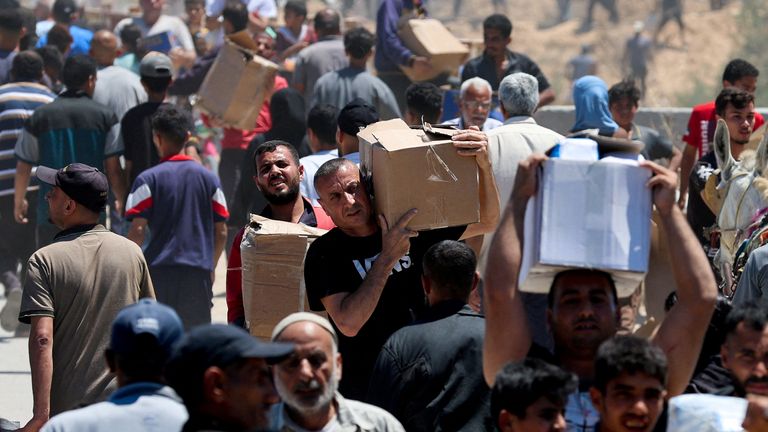 Palestinians carry aid supplies they received from the U.S.-backed GHF, in the central Gaza Strip, 29 May. Pic: Reuters
