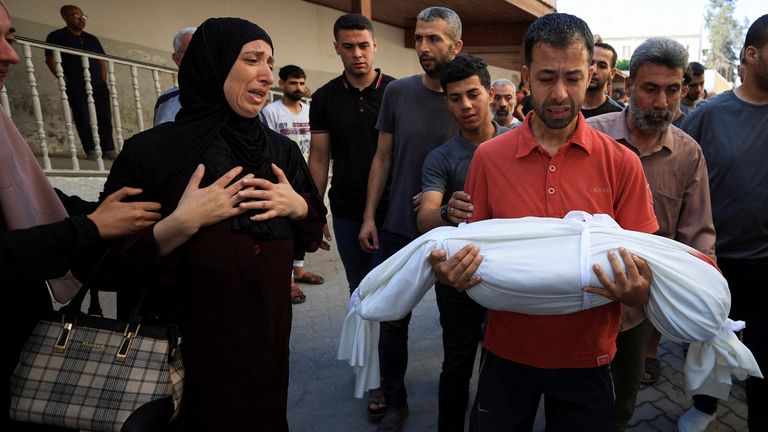 Mourners react near the body of a Palestinian child killed in an Israeli strike on a house late at night, according to Gaza's health ministr