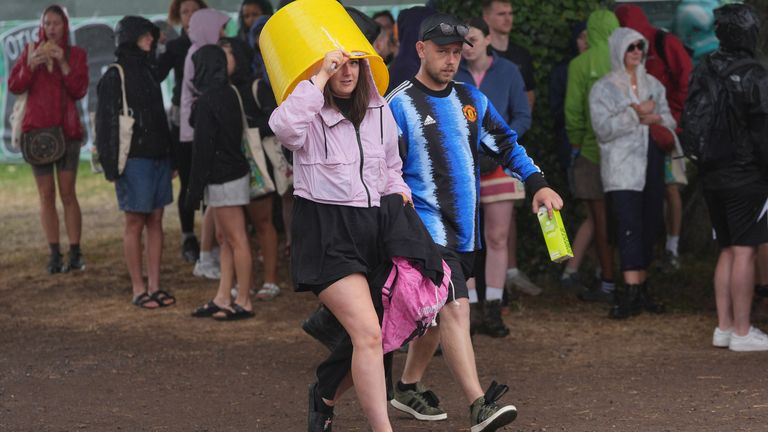 Revellers at the Glastonbury Festival during a shower.
Pic:Reuters