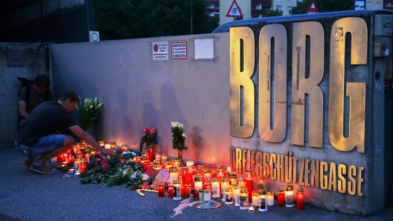 A man places a candle at the entrance to a school after a deadly shooting, in Graz, Austria. Pic: AP Photo