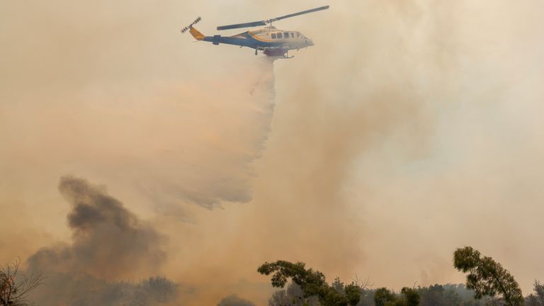 Helikopter robi spadek wody, gdy pożar pali się w pobliżu wioski Agios Georgios Sikeusis, na wyspie Chios na Grecji. Zdjęcie: Reuters
