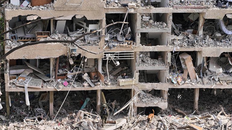 Rescue workers inspect the site of an Iranian missile strike in Tel Aviv, Israel on Sunday. Pic: AP