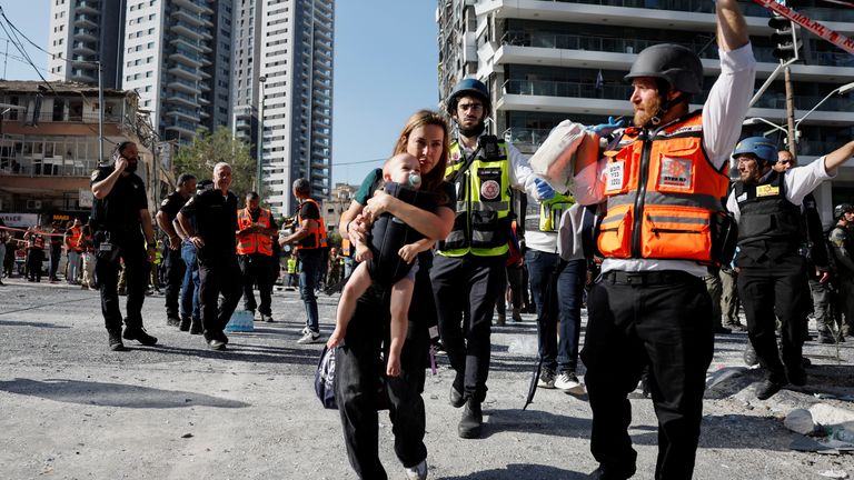 A woman carries her child at an impact site following a missile strike from Iran on Israel, in Ramat Gan, Israel.
Pic: Reuters