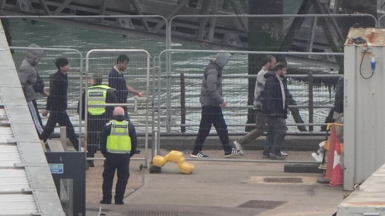 Migrants who arrived on small boats walk off a rescue vessel in Dover, Kent. Pic: PA