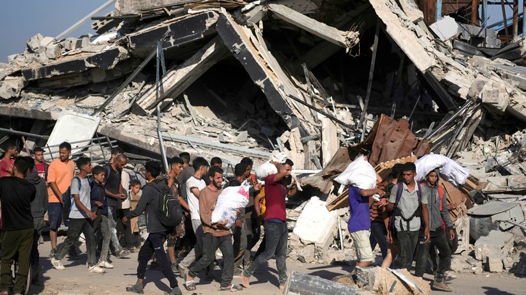 Palestinians carry humanitarian aid packages distributed by the Gaza Humanitarian Foundation in Khan Younis.
Pic: AP