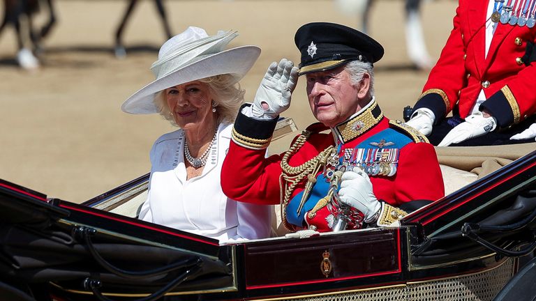 O rei do rei Chartithan, Chartithan, e a sra. Camilla andam no carrinho como parte da armadilha para colorir deslizantes. Imagem: Reuters