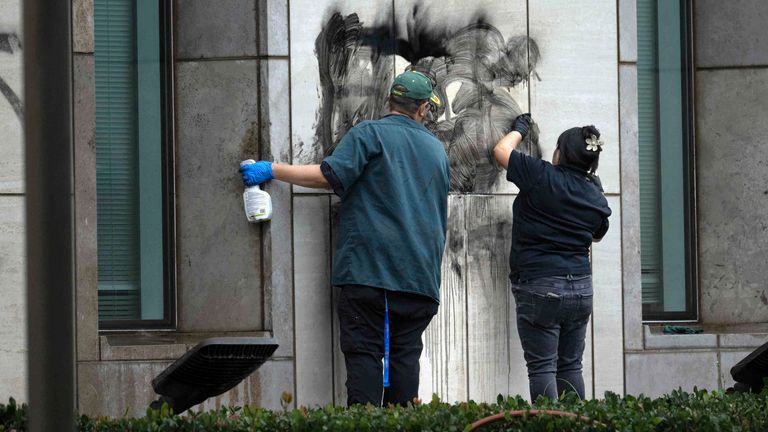 Workers remove graffiti from the Ronald Reagan Federal Building in Santa Ana. Pic: Mindy Schauer/The Orange County Register via AP