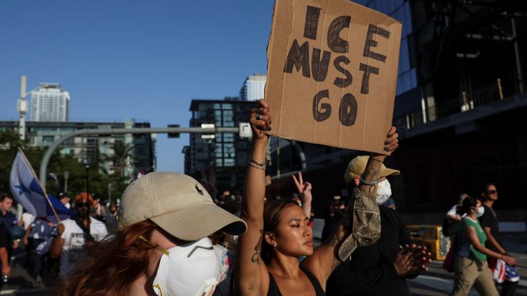 A protester holds up a placard while marching through downtown LA. Pic: Reuters/Leah Millis