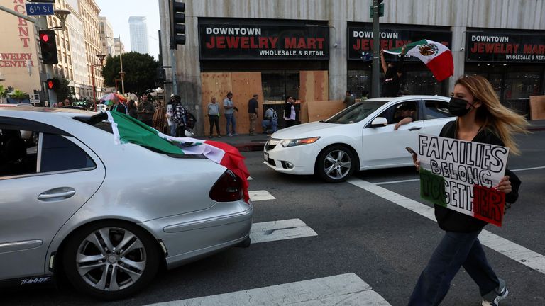 A protester marches past businesses being boarded up. Pic: Reuters/Leah Millis
