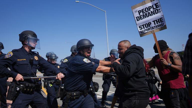 California Highway Patrol officers clash with protesters in LA. Pic: AP/Eric Thayer