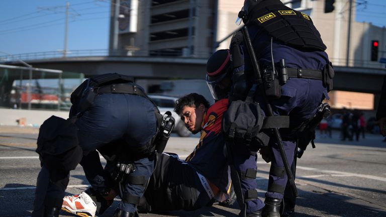 A protester is arrested by law enforcement officers in downtown LA. Pic: AP/Eric Thayer