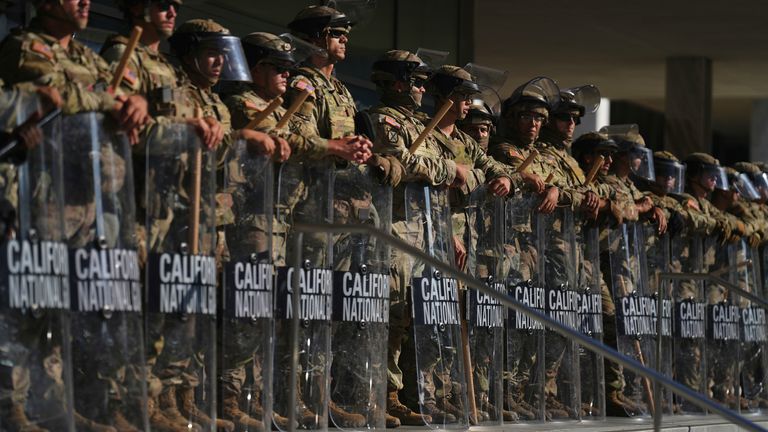 National Guard troops are lined up to protect a federal building in downtown LA. Pic: AP/Eric Thayer