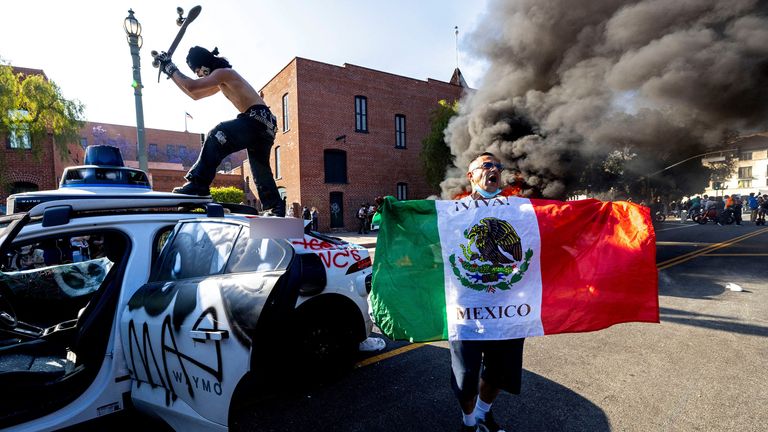 Bir gösterici, 8 Haziran 2025'te Los Angeles, Kaliforniya, ABD, Federal Göçmenlik Süpürmelerine Karşı Bir Protesto Sırasında Bir Waymo Kendi Kendi Kendine Sürüş Arabasına Giriyor.     