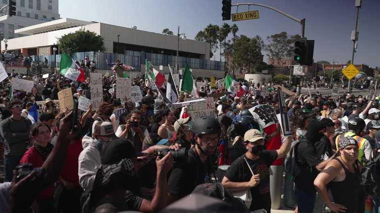 Anti-ICE protesters carrying pro-immigration signs and Mexican flags outside Los Angeles city building