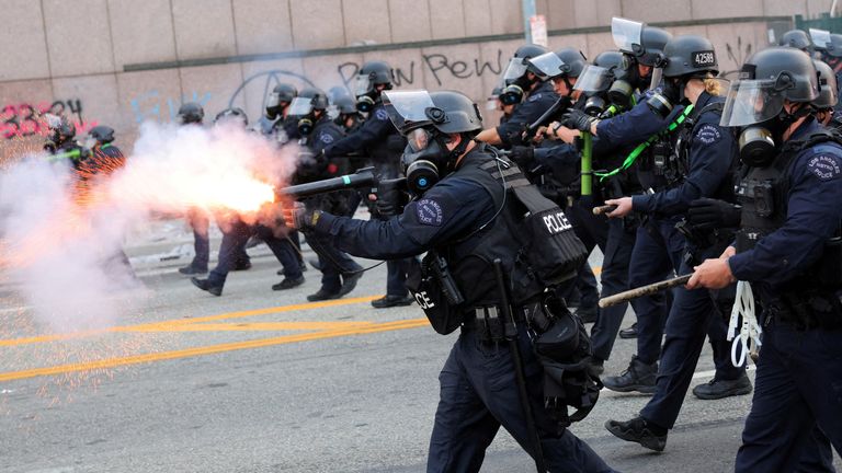 Police fire stun grenades at protesters outside the Los Angeles Federal Building in Los Angeles on Friday. Pic: Reuters