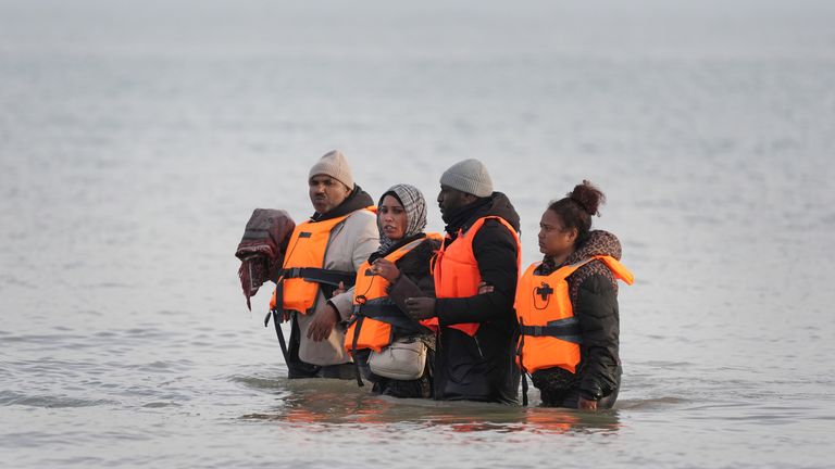 People waded through the shallows to get on small boats. Pic: PA