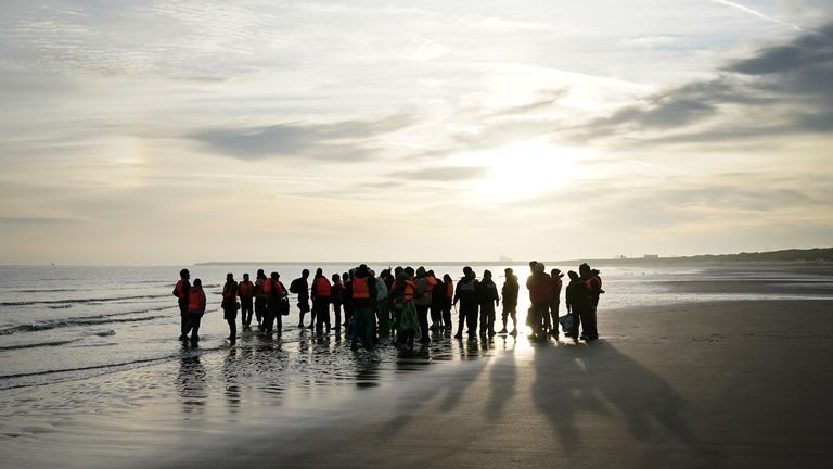 Migrants waited for the boats to come to the beach before wading in to the shallows to board. Pic: PA