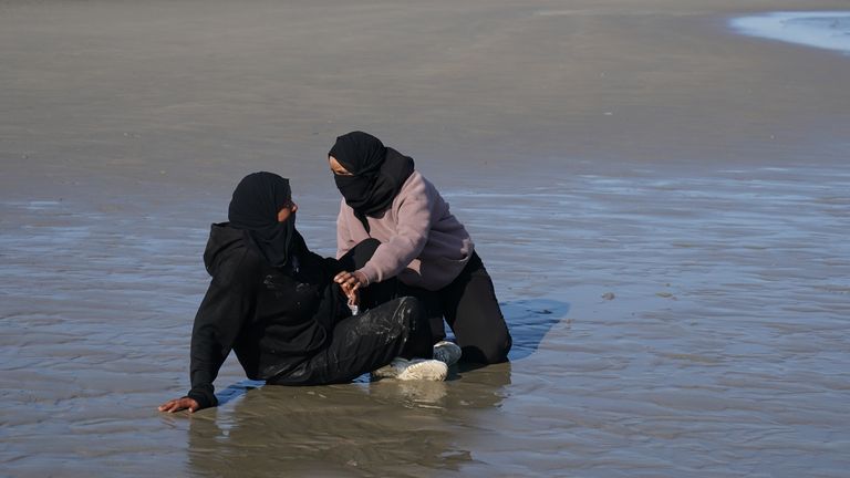 People thought to be migrants on the beach at Gravelines, France, as they wait to board a small boat in an attempt to reach the UK by crossi