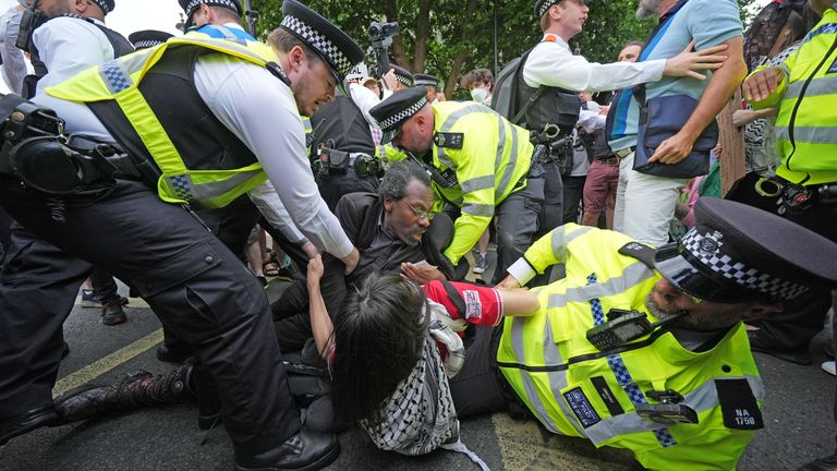 Police officers remove people taking part in a demonstration at Trafalgar Square in London. Pic: PA
