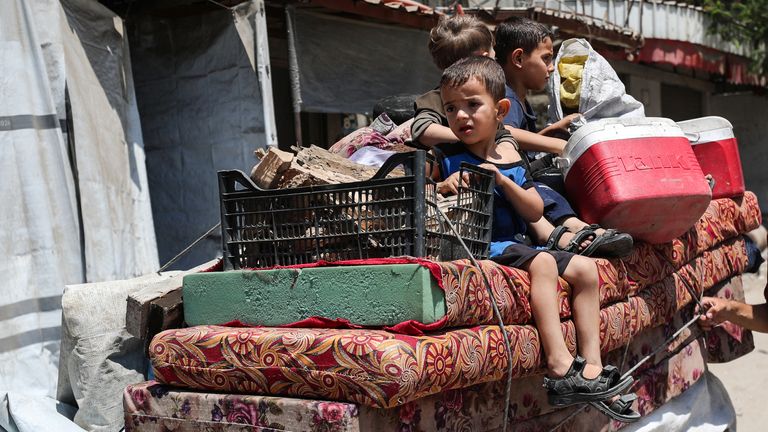 A child looks on as Palestinians flee their homes with their belongings after the Israeli army issued evacuation orders, in Gaza City, June 