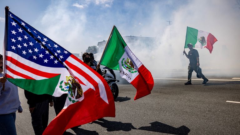 Mexican and US flags are flown by protesters in Paramount. Pic: Reuters