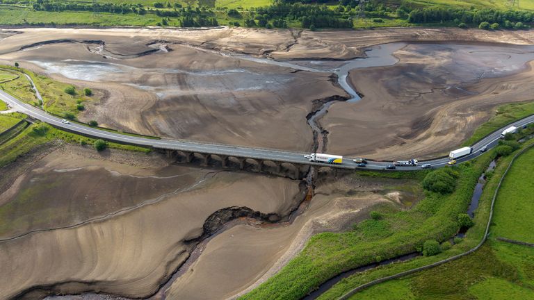 A drone view shows vehicles using a bridge to pass over a dry section of the Woodhead Reservoir.
Pic: Reuters