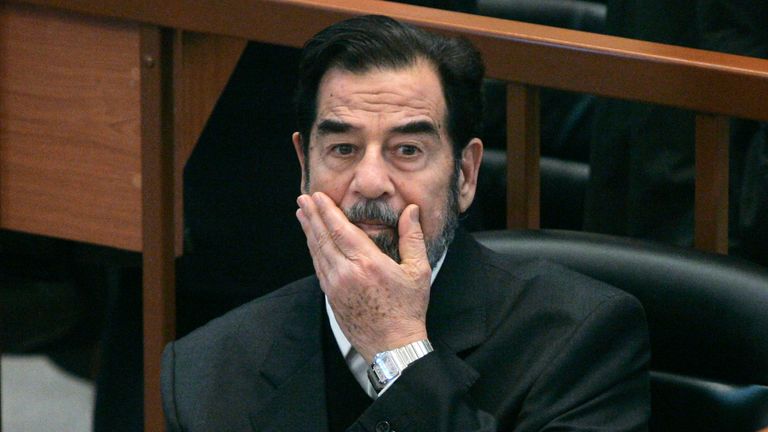 Saddam Hussein gestywa się, gdy patrzy, jak materiał filmowy przedstawiony przez prokuraturę podczas badania ludobójstwa anfal w Bagdadzie. Zdjęcie: Reuters