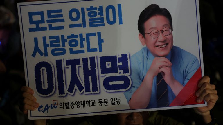 Güney Kore Demokrat Partisi başkan adayı Lee Jae-Myung'un bir destekçisi bir işaret tutuyor. Pic: Reuters