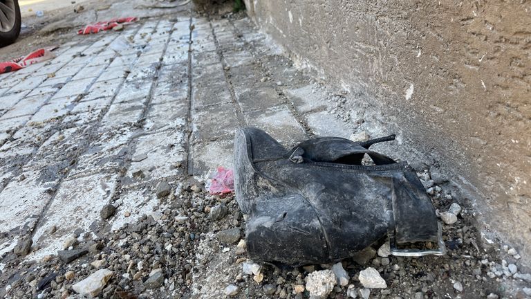 Ayakkabılar da dahil olmak üzere enkaz, füzenin etkisi ile caddenin karşısına atıldı