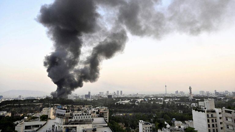 Black smoke billows from the headquarters of Iranian state television in Tehran following an Israeli attack