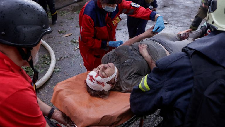 Rescuers and paramedics carry an injured resident after she was freed from debris in Kharkiv.
Pic: Reuters/Sofiia Gatilova