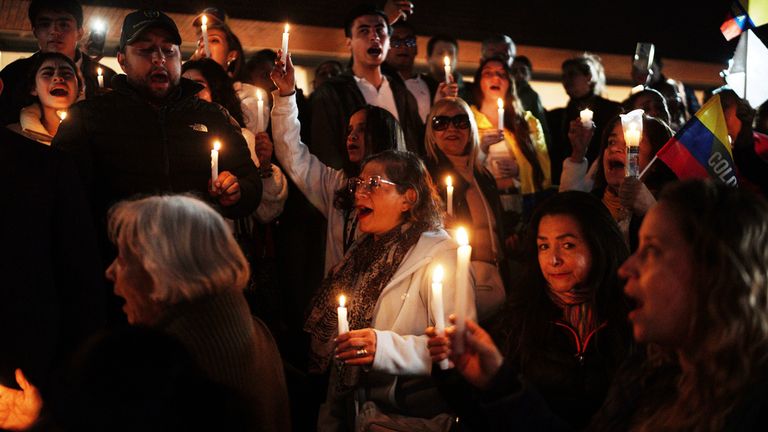 People hold candles as they gather outside the  where Colombian Senator Miguel Uribe Turbay
