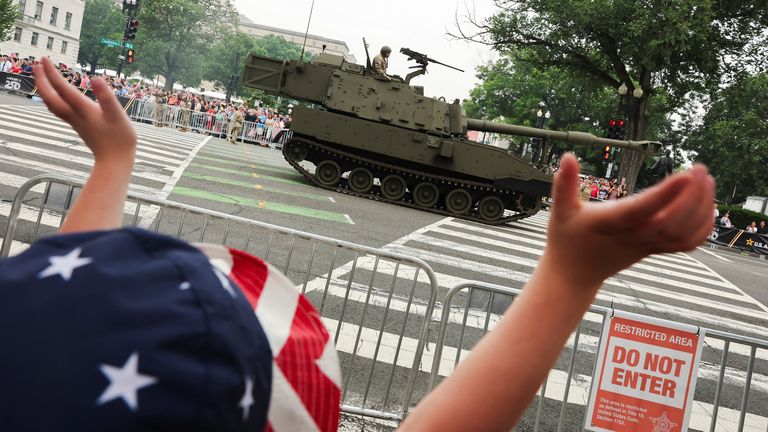 A child waves as a tank passed. Pic: Reuters