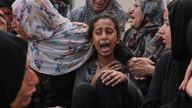 Lian Al-Za'anin, center, is comforted by relatives as she mourns the loss of her father, Rami Al-Za'anin, who was killed while heading to an aid distribution hub, at the morgue of the Shifa Hospital in Gaza City, on Thursday, July 3, 2025. (AP Photo/Jehad Alshrafi)