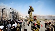 Members of Israeli security forces stand at the ceasefire line between the Israeli-occupied Golan Heights and Syria.
Pic: Reuters