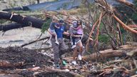 People climb over debris on a bridge atop the Guadalupe River after a flash flood. Pic: AP