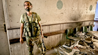 A Druze fighter in a destroyed hospital corridor