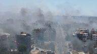 Smoke rises from buildings in the city centre of Sweida