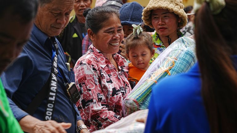 Local villagers receive supplies provided by a charity, in Wat Phnom Kamboar, Oddar Meanchey province, Cambodia, Sunday, July 27, 2025, amid the fighting between Thailand and Cambodia. (AP Photo/Heng Sinith)