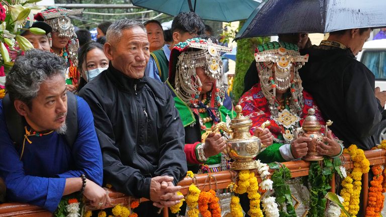 Devotees in their traditional dress wait for the arrival of the Tibetan spiritual leader. Pic: AP/Ashwini Bhatia
