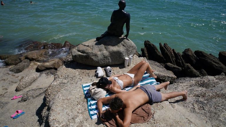 Folkestone'daki Sunny Sands Plajı'ndaki sıcak havanın tadını çıkaran insanlar. Pic: PA 