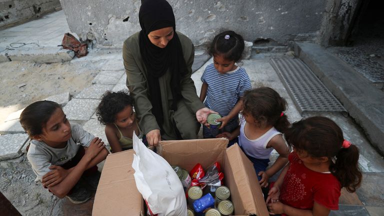A woman with an airdropped food parcel in Gaza City. Pic: Reuters