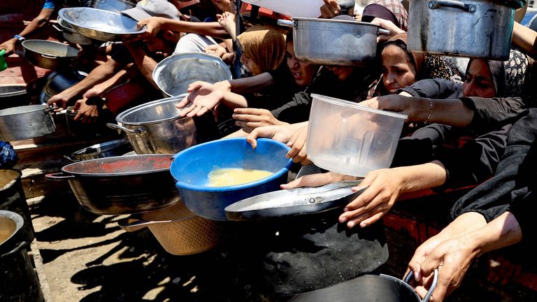 Palestinians gather to receive food from a charity kitchen, amid a hunger crisis, in Gaza City.
Pic: Reuters