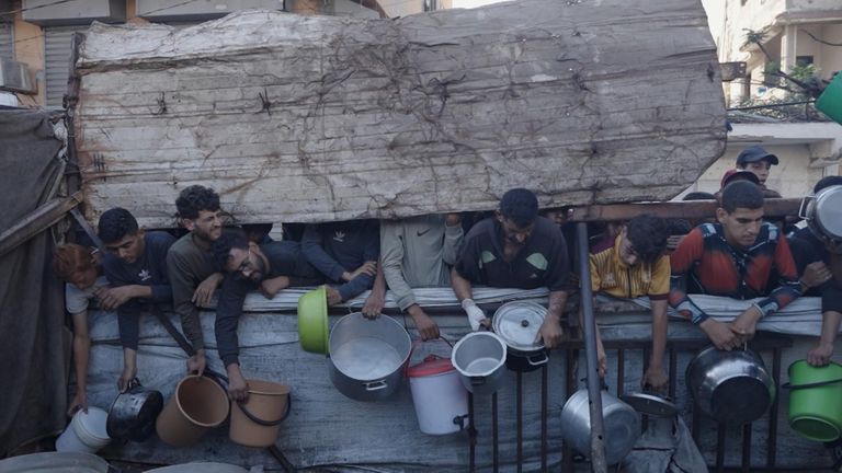 People wait at a soup kitchen 