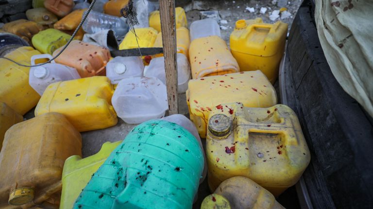 Blood stains are seen on containers at the water collection point. Pic: Reuters