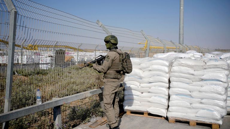 An Israeli soldier stands beside aid packages on the Palestinian side of the Kerem Shalom crossing in the Gaza Strip.
Pic: AP