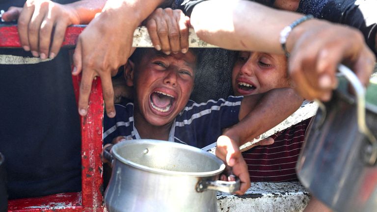 Palestinians wait to receive food from a charity kitchen, amid a hunger crisis, in Gaza City.
Pic: Reuters